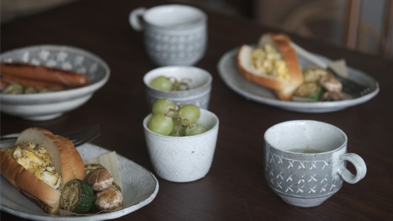 兵山窯 Siksak 系列的盤子與杯子,盛著麵包、香腸和葡萄的早餐